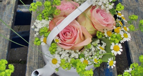 Teekanne auf Holztisch mit Blumen